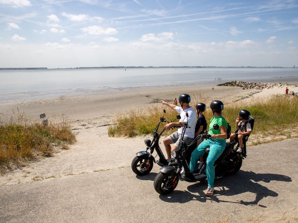 Mensen op scooter oftewel soort fiets die beveland daarop ontdekken